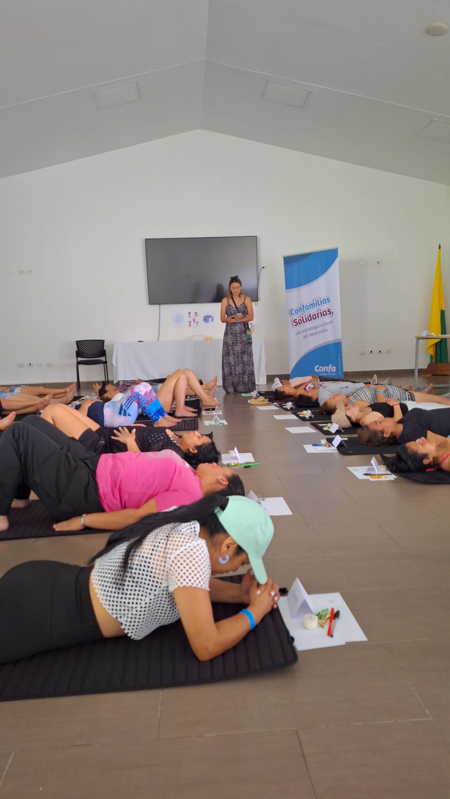 Mujeres recostadas en un salón durante una sesión de relajación guiada en el encuentro con mujeres