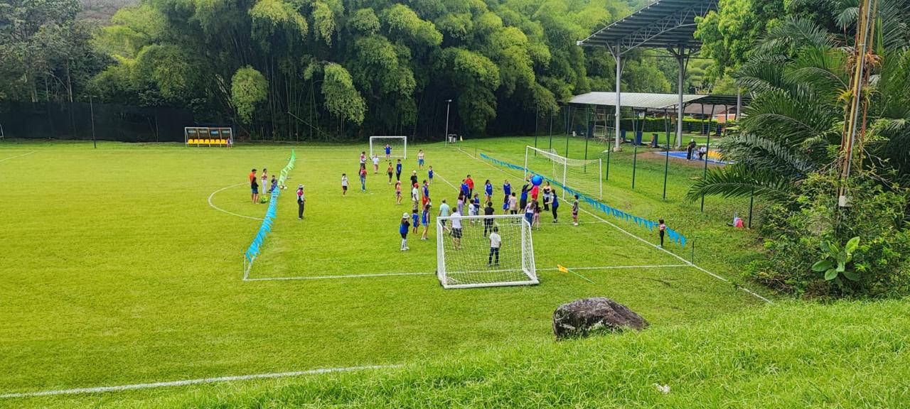 Niños jugando fútbol en un campo de césped durante la jornada de Confamilias