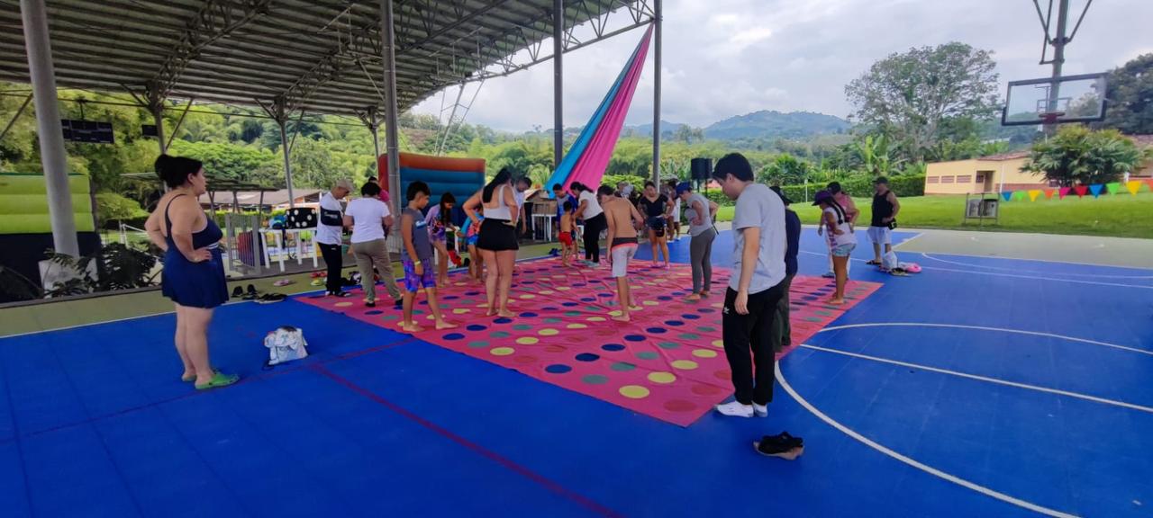Niños jugando en la cancha cubierta con adornos de colores durante la jornada de Confamilias