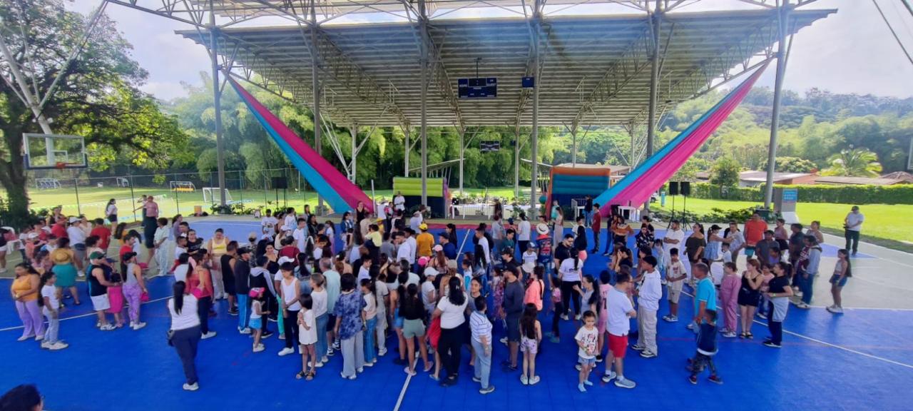 Niños y familias reunidos en una cancha cubierta durante la jornada de Confamilias Solidarias