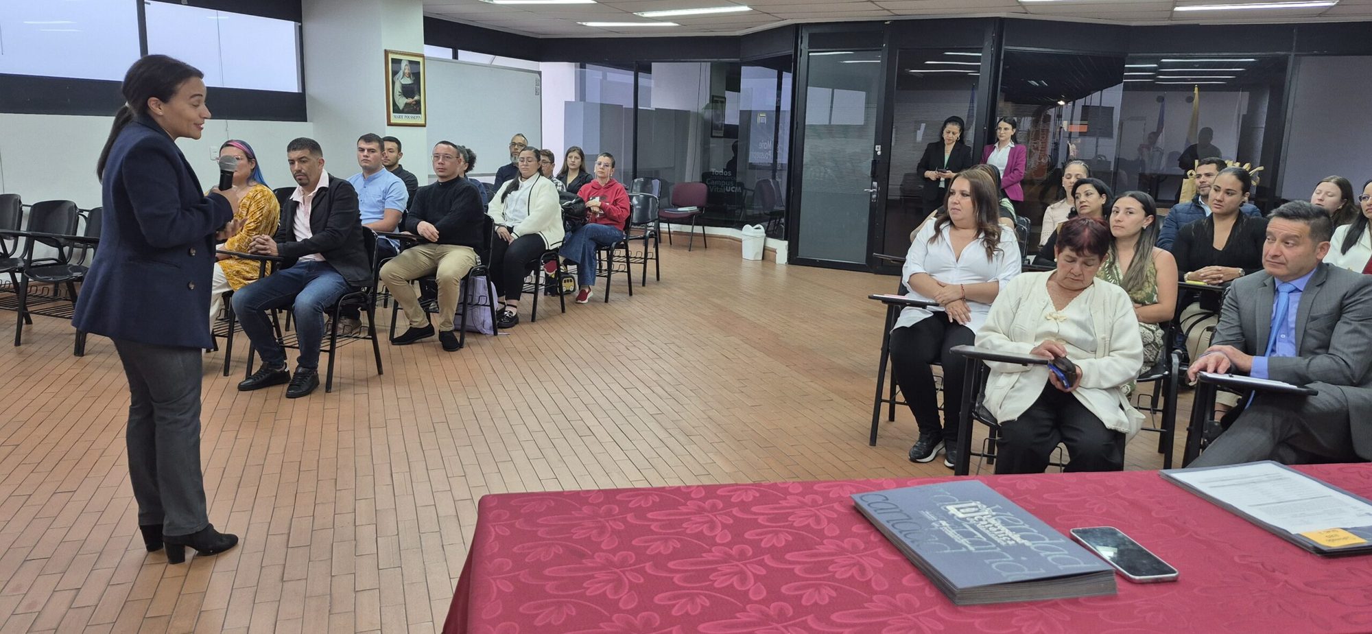 Una mujer de pie frente a los asistentes durante la ceremonia de certificación de Formación T