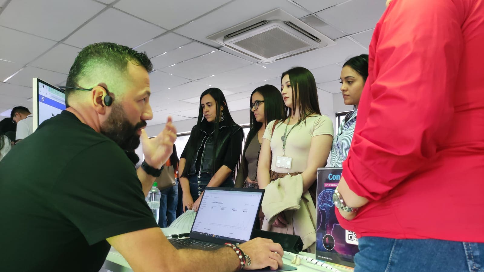 Personas reunidas frente a un computador escuchando como se trabaja la IA en Confa