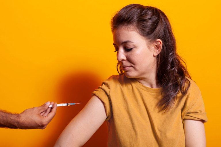 Mujer recibiendo una vacuna en su brazo