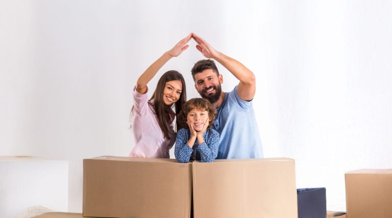 Una familia feliz construye casa con sus brazos. Motiva por el subsidio de vivienda de Confa