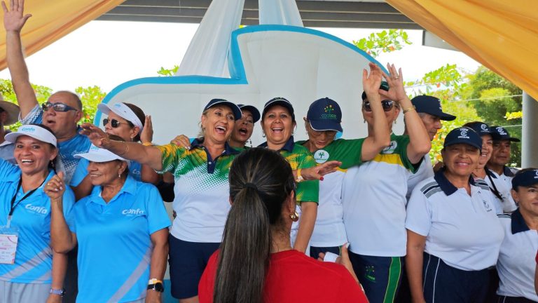 Adultos mayores de distintas delegaciones celebrando y saludando con los brazos en alto durante la clausura de los juegos deportivos