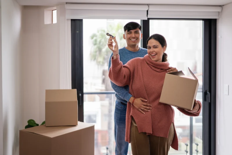 Pareja estrenando su casa con cajas de mudanza
