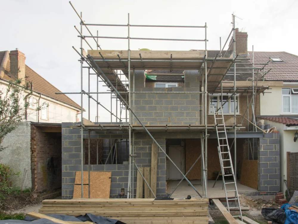 Casa en construcci&oacute;n con andamios y muros de bloque
